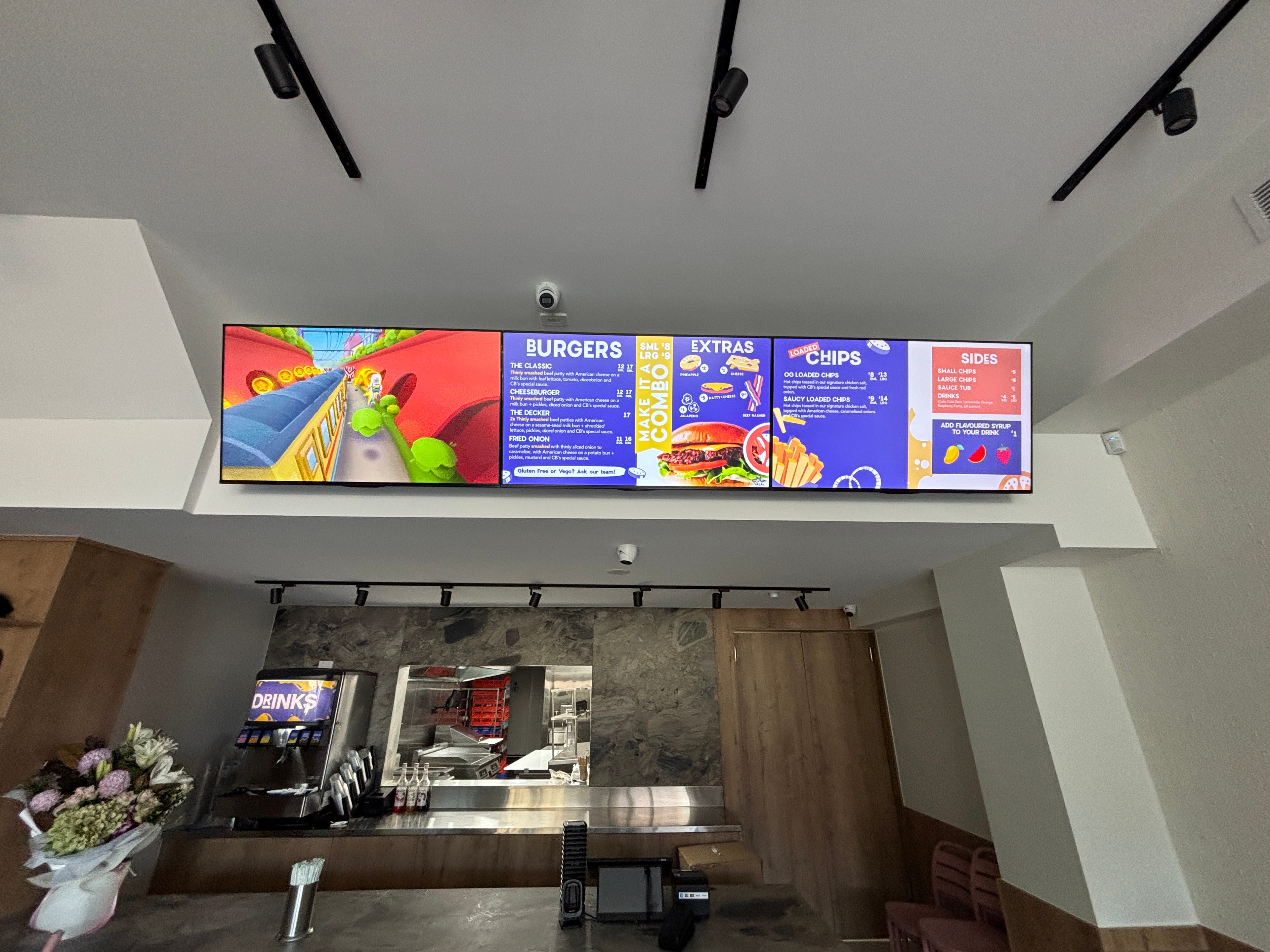 Fast food restaurant ceiling-mounted digital menu board installed by NCC Solutions